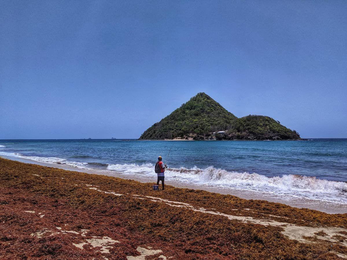 Гренада, пляж Levera Beach, рыбак и вид на остров – фотографии Гренады