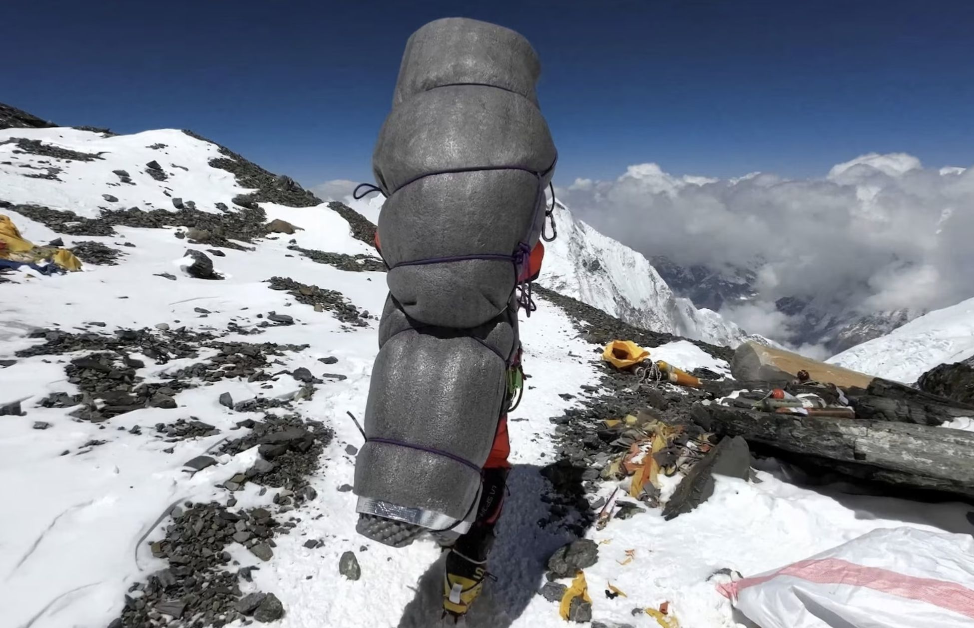 Шерпа тащит туриста-альпиниста